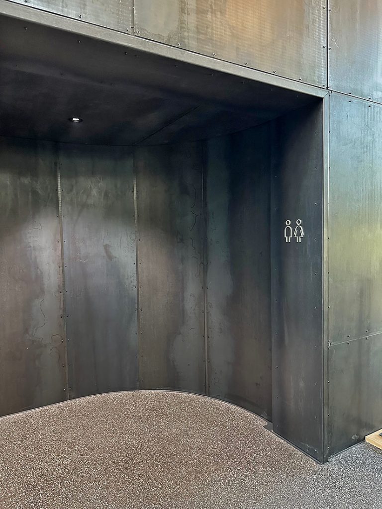 Bergson Atrium Zugang Toiletten mit Stahlplatten verkleidet